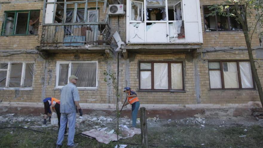 Operarios limpian escombros en Gorlovka, Ucrania, tras un ataque.