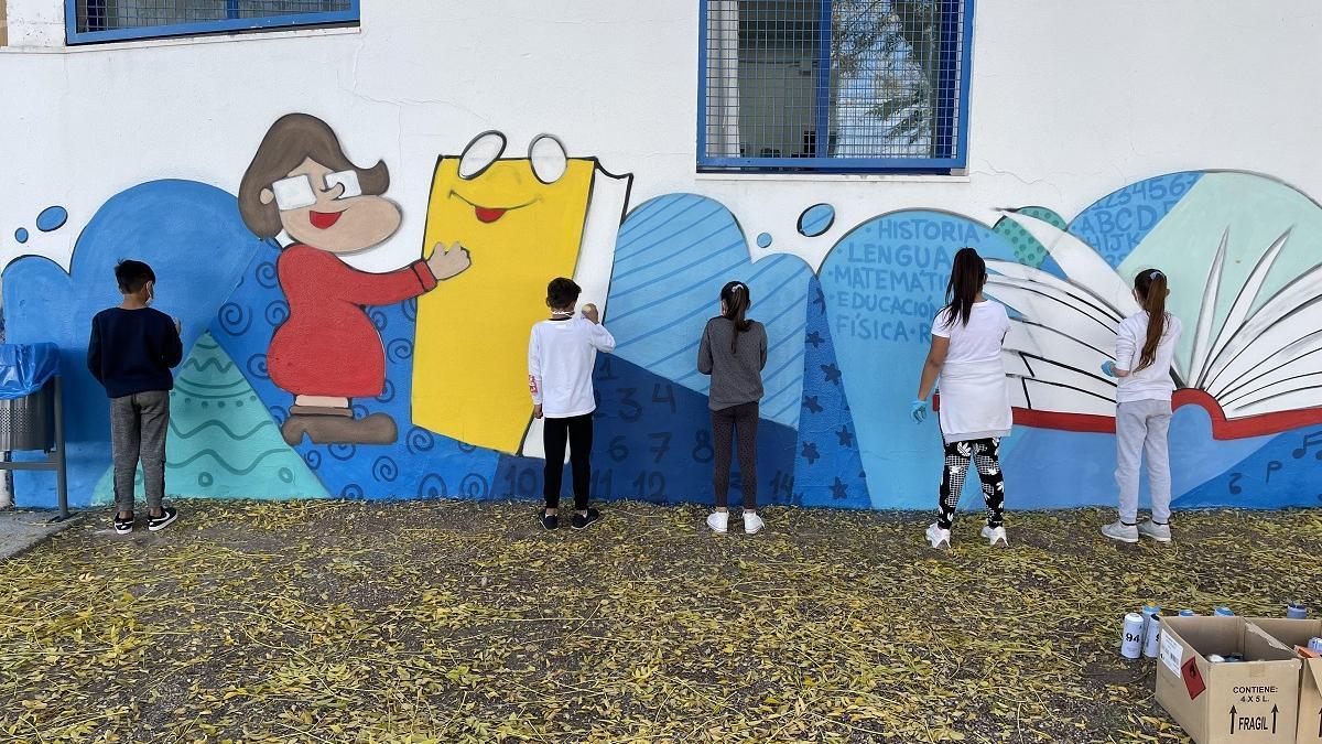 A golpe de color: Alumnado del CEIP Los Mochos pintando uno de los muros del centro con grafitis.