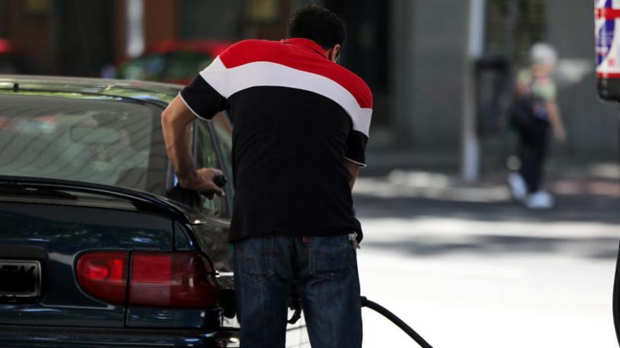 Un hombre echa gasolina a su coche.