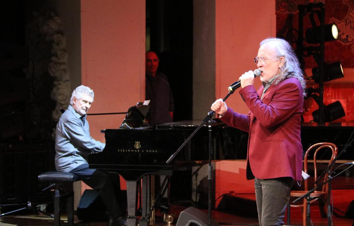 Manel Camp, al piano, mira Joan Reig, amb Lluís Llach al fons de l'escena