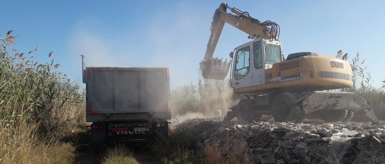 Momento en que una máquina excavadora retira los escombros y los carga en un camión.