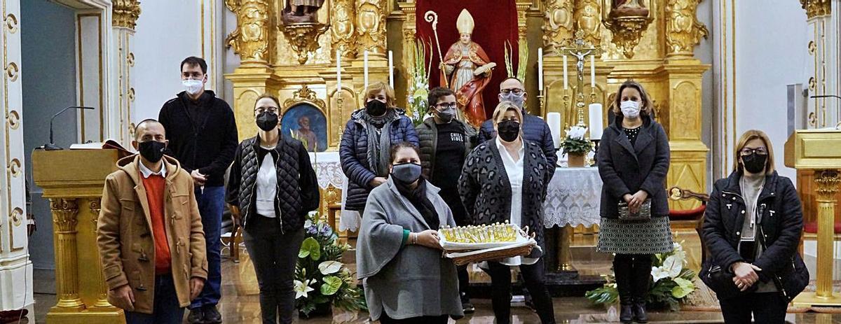 Festeras y festeros de Sant Bali, con el párroco y las monodosis de aceite bendecidas ayer. | LEVANTE-EMV