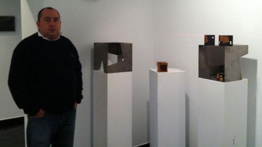 Amador Rodríguez junto a algunas de las piezas de la muestra, entre ellas una reproducción del Cubo de Candás.