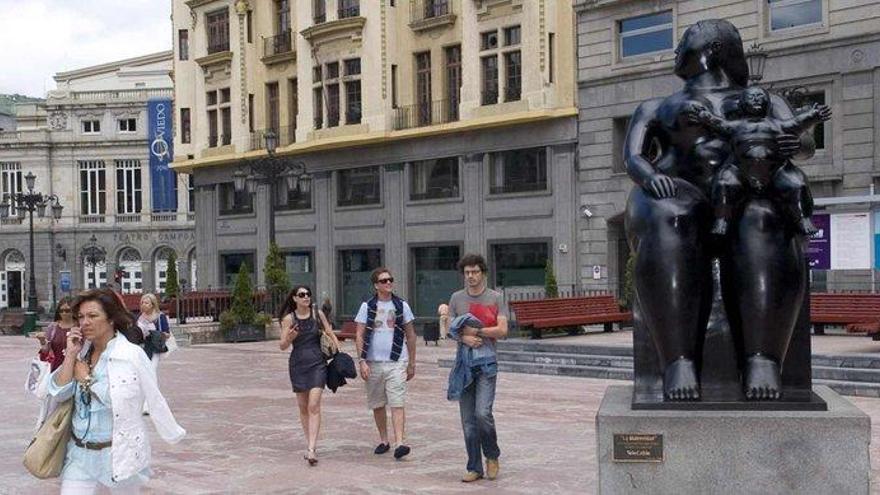 La &quot;Maternidad&quot; de Botero, en la plaza de la Escandalera, observada por los viandantes.