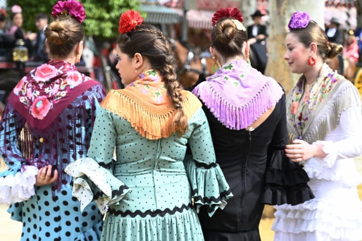 Jóvenes con traje de flamenca  en una calle del Real el Jueves de Feria