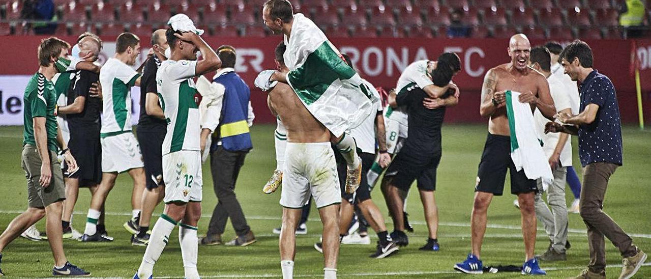 Los jugadores del Elche celebran en la noche del domingo al lunes en Montilivi su ascenso a Primera con el técnico Pacheta a la derecha.