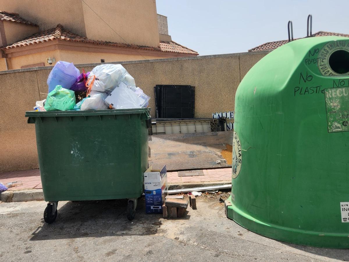 Así están los contenedores de basura de San Miguel de Salinas: hasta arriba de podas y enseres sin que Actúa los retire