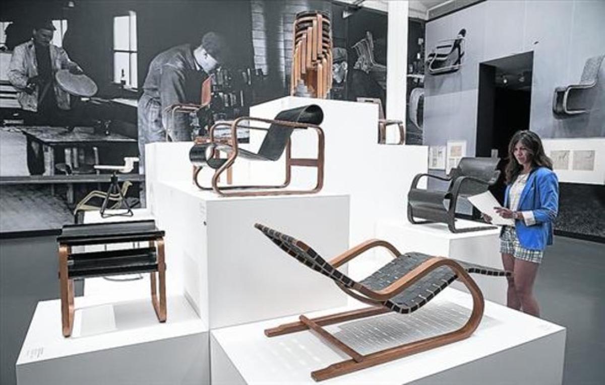 Una visitant a CaixaForum, davant alguns dels mobles dissenyats per Alvar Aalto, com (a dalt) el famós tamboret apilable 60, del 1933.