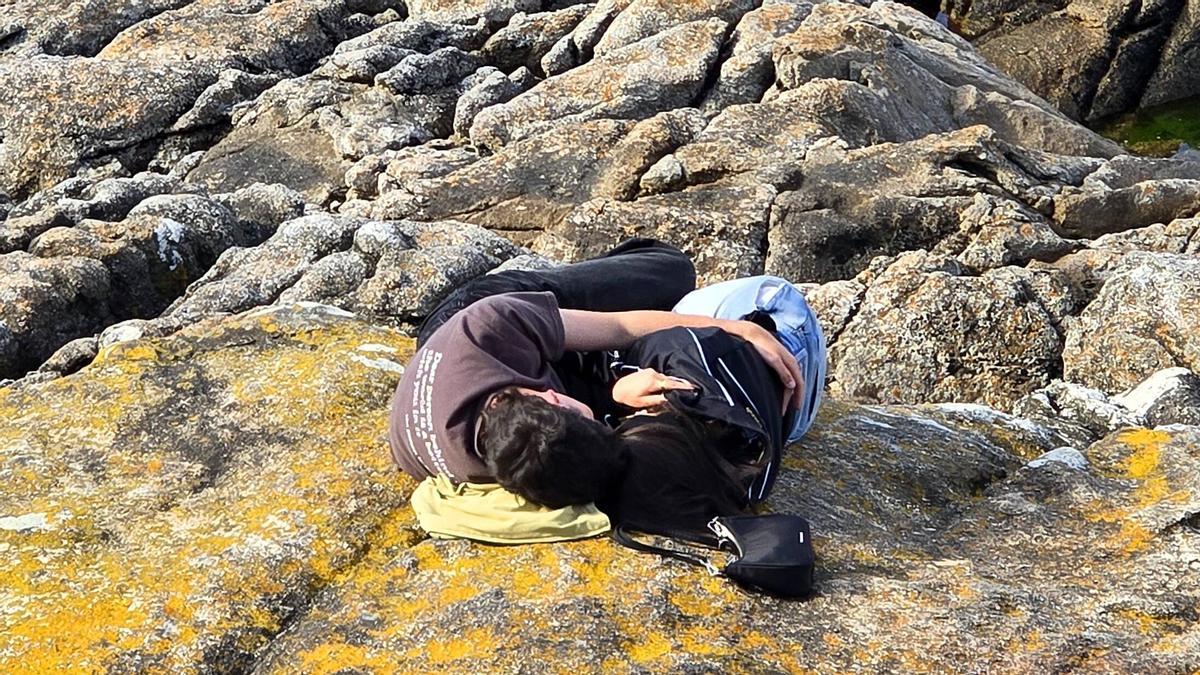Pareja de novios abrazada en las rocas junto al Monte Boi, en Baiona.