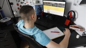 Un alumno de tercero dela  ESO hace las tareas escolares con su ordenador en casa, el 14 de abril en Barcelona.