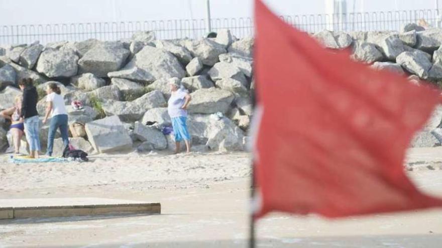 Una bandera roja ondea, ayer, en la playa de Oza.