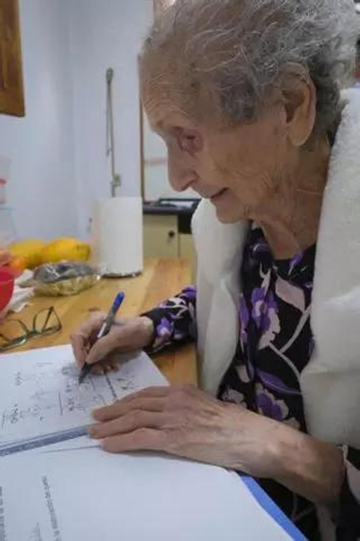 Dolores Campos Brito, de 92 años, escribe en uno de sus cuadernos.