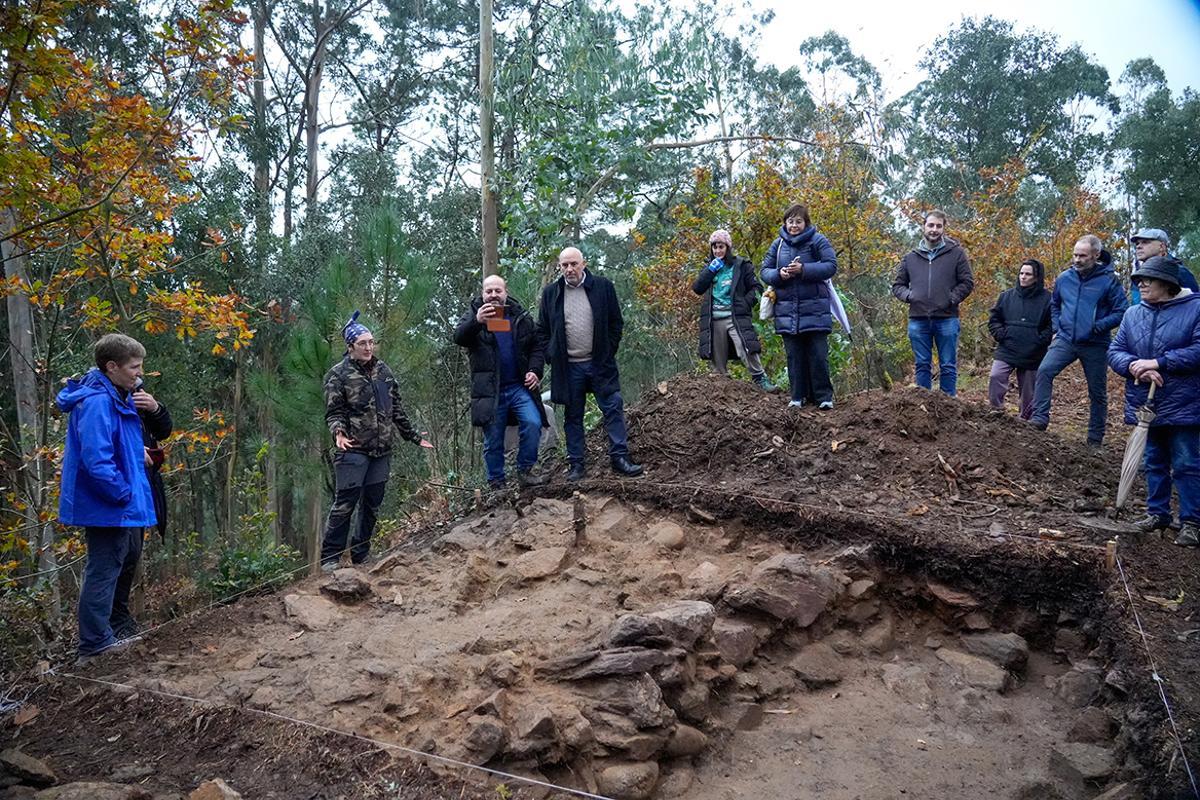 A arqueóloga Lupe Castro, segunda pola esquerda, co alcalde, José Carlos Vidal, no centro, e os veciños na visita ao xacemento.