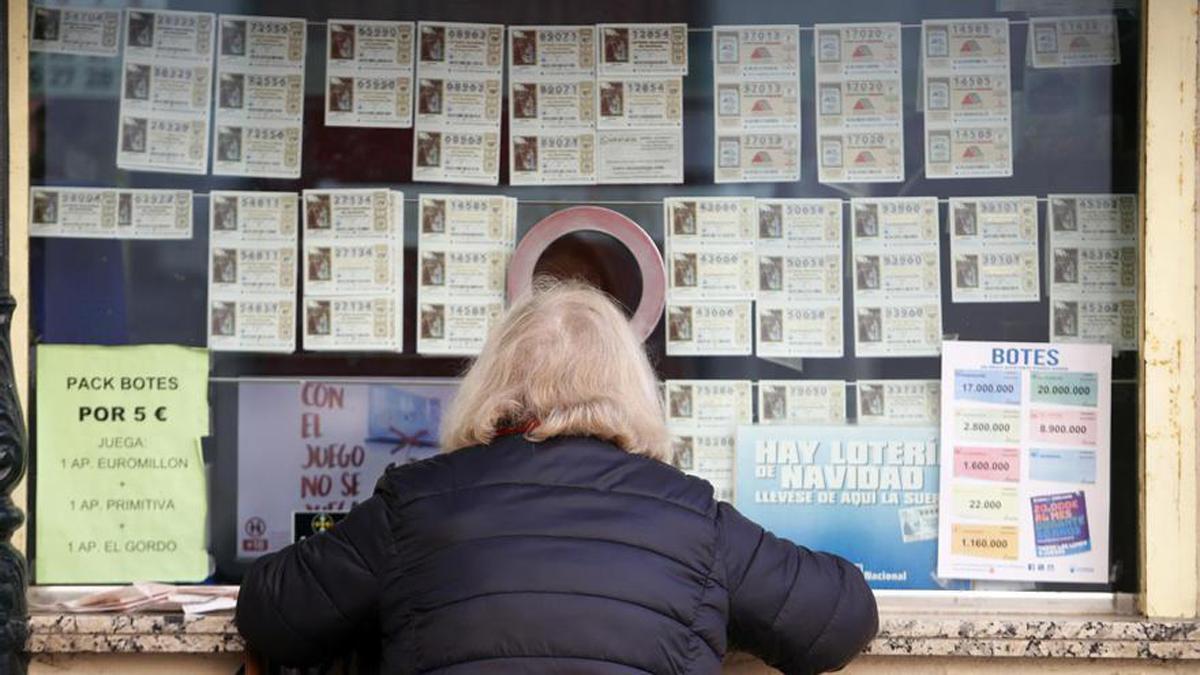 Una persona compra décimos de la Lotería.