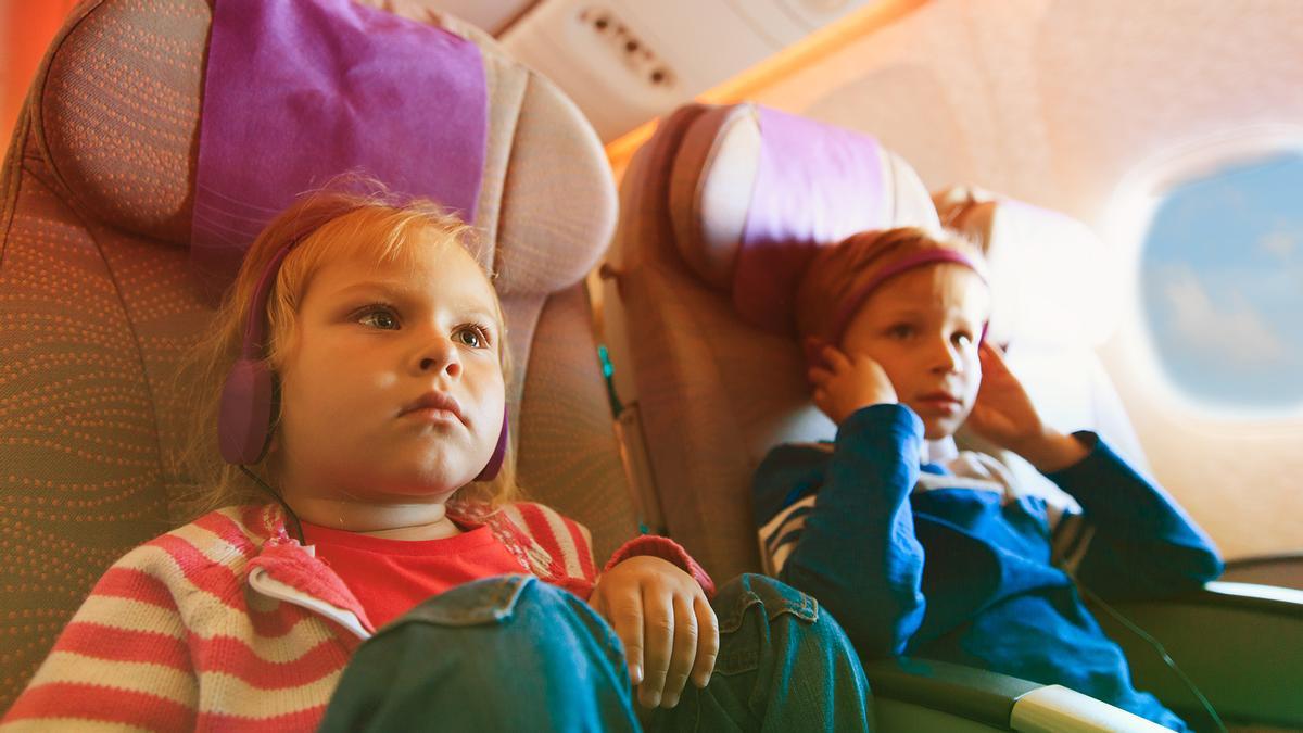 Dos niños viajando en avión