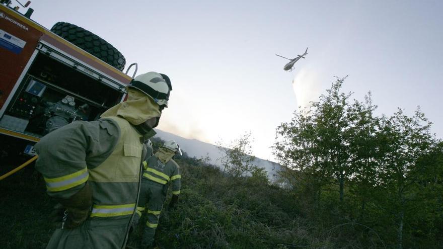 Efectivos, en Cabanelas, observando la actuación del helicóptero.