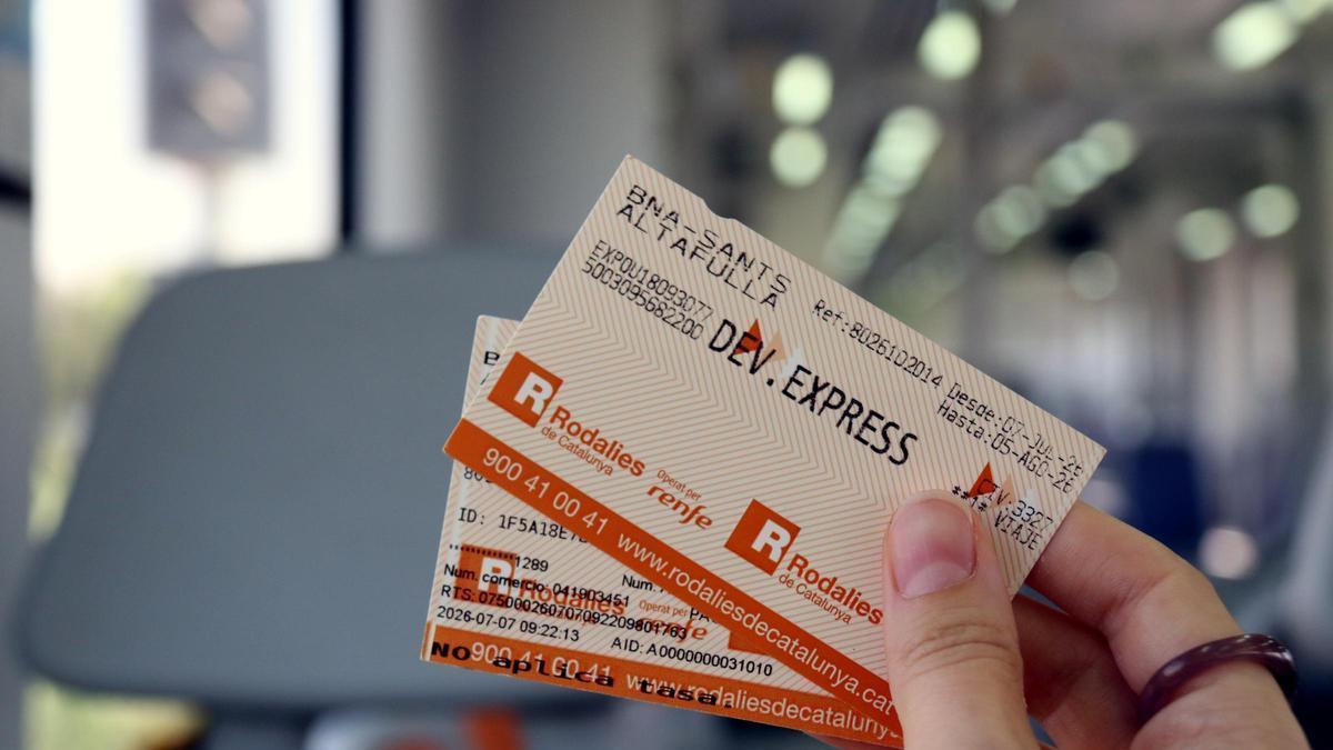 Un usuari amb un bitllet de devolució de Rodalies