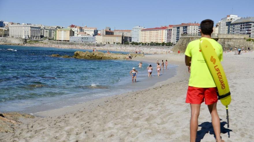 Un socorrista vigila a los bañistas en la playa del Orzán.