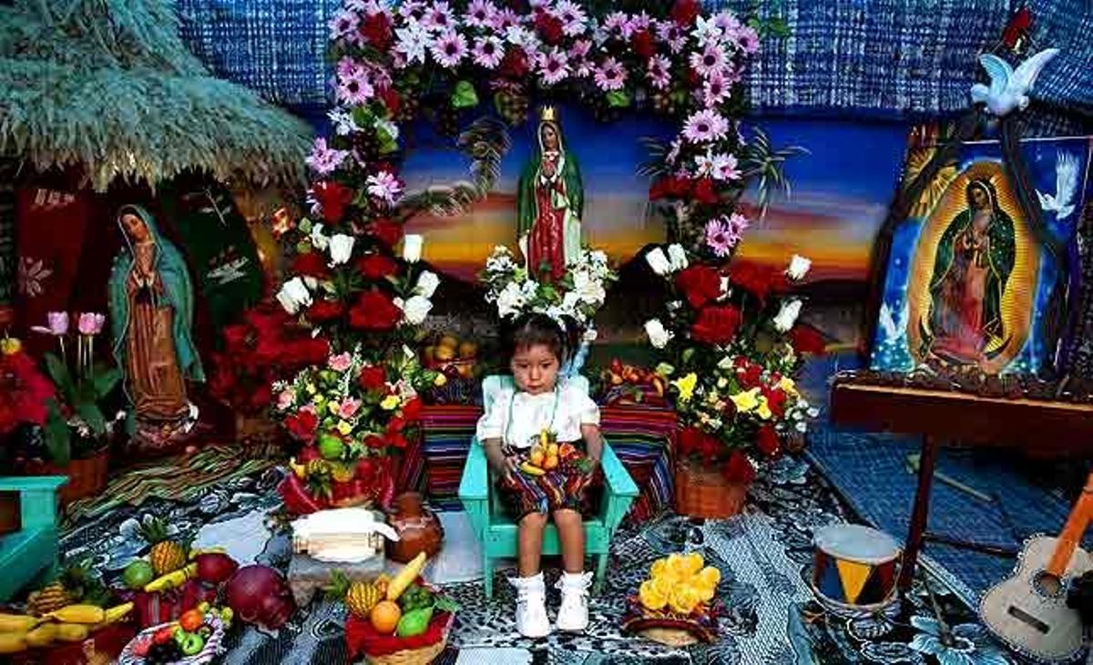 Una nena s’asseu envoltada d’imatges de la Verge de Guadalupe per fer-se una foto, a prop de la Basílica de la Verge a la ciutat de Guatemala (Guatemala).