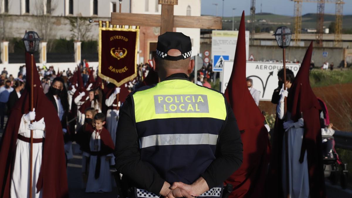 Un agente de la Policía Local regula el tráfico al pasado de una hermanda.