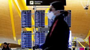 Una persona con mascarilla por el coronavirus, en el aeropuerto de Madrid.