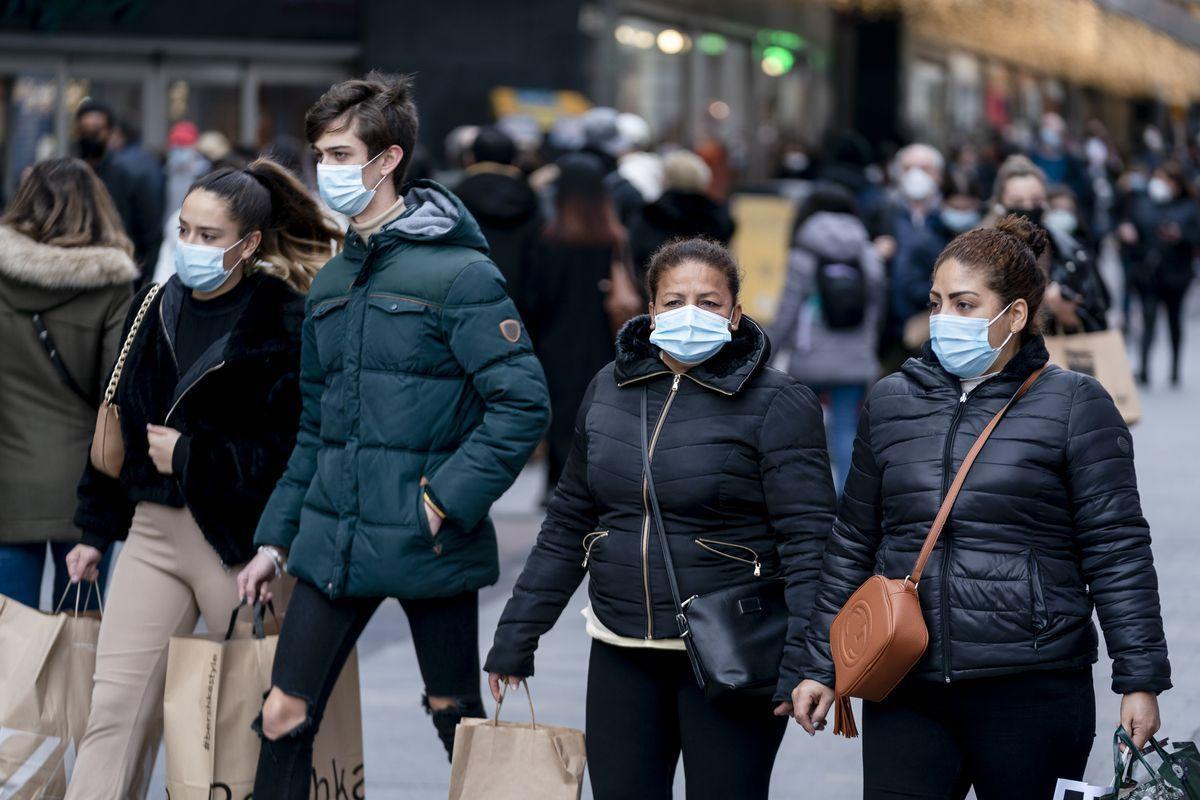 Varias personas hacen sus compras en Madrid, este jueves, con las mascarillas puestas.