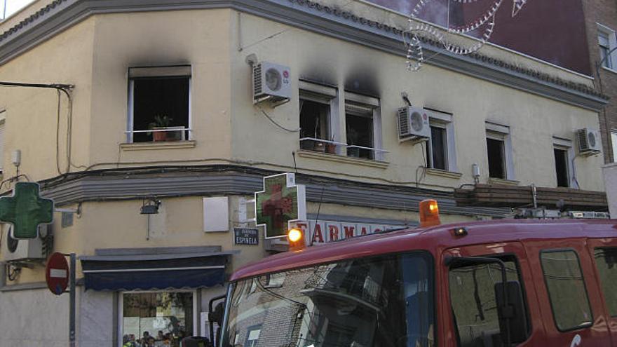 Los bomberos trabajan en las labores de extinción de un incendio en una vivienda de la calle Espinela de Villaverde provocado por un hombre de 34 años que fue detenido acusado de provocar el fuego y de intentar matar a su madre.