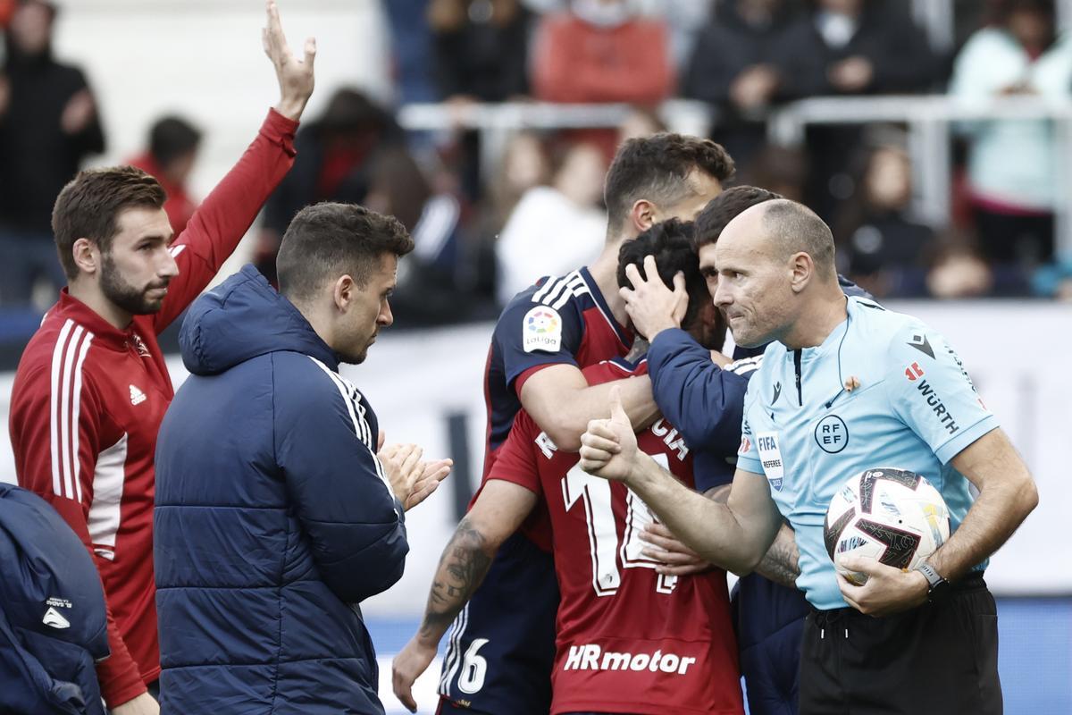 El árbitro valenciano conversa con los jugadores de Osasuna tras el partido contra el Almería.