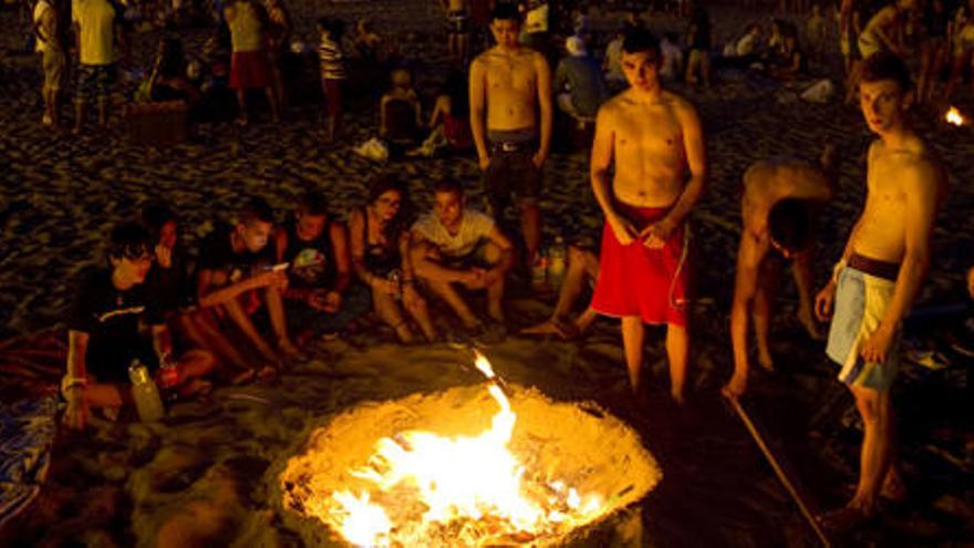 Varios jóvenes celebran la noche de San Juan en la playa de la Malva-rosa. Foto: Fernando Bustamante.