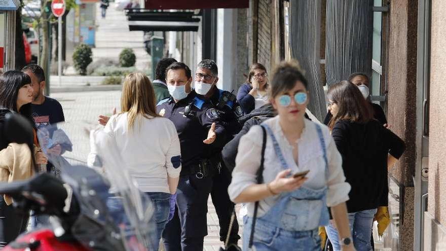 Agentes de la Policía Local de Vigo, ayer, con trabajadores de la empresa Unísono. // Alba Villar