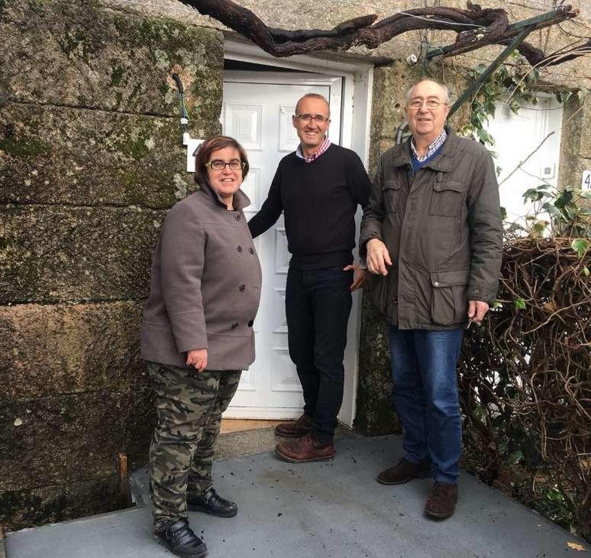 El alcalde, Juan González, abre la puerta de la casa junto a dos componentes del Centro Juan María. // D.P.