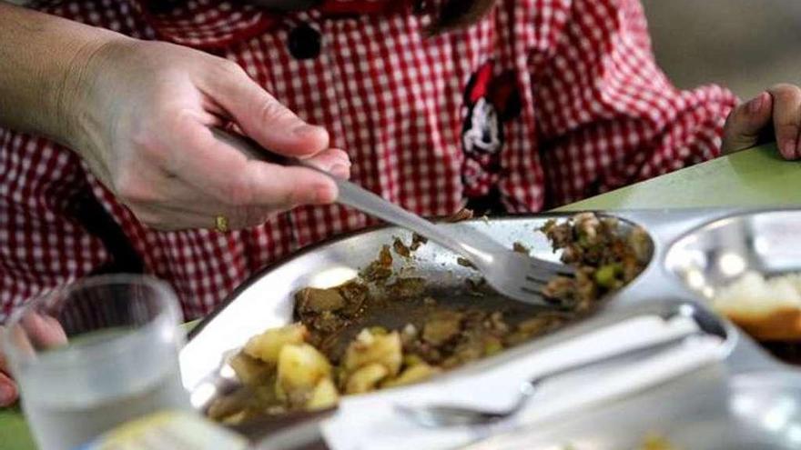 Un menor se alimenta en un comedor escolar.