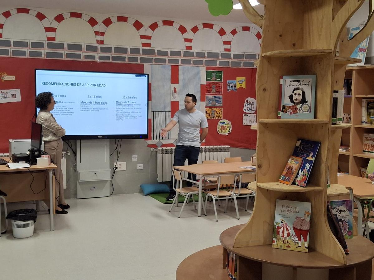 Los pediatras imparten la charla en la biblioteca del colegio.