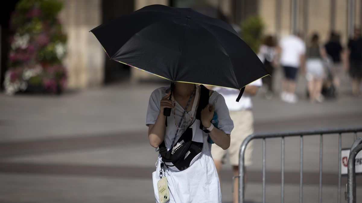 Una mujer se protege del calor con un paraguas en Zaragoza, este domingo.