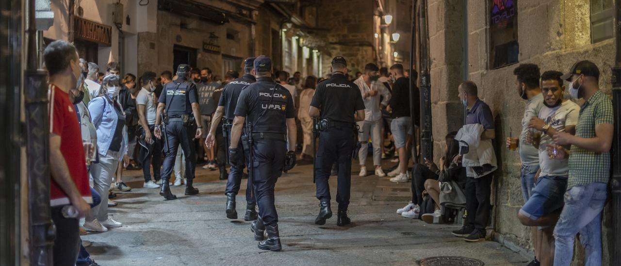 Efectivos de la Policía Nacional hacen ronda de vigilancia por una de las calles de Vinos del casco histórico de Ourense.