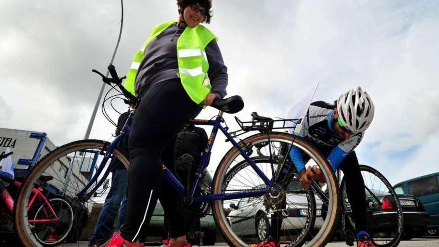 César Veloso pone a punto la bicicleta de la candidata del BNG antes de iniciar el paseo. // Iñaki Abella