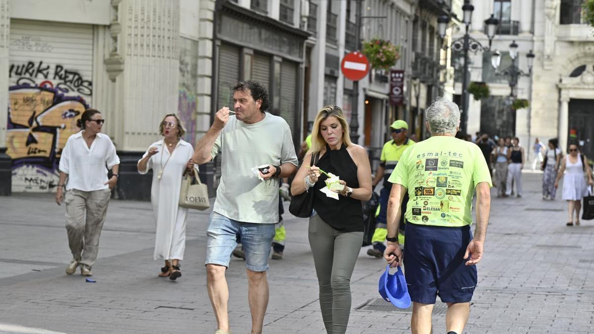 Dos personas se comen un helado en el centro de Zaragoza, este lunes durante la ola de calor.