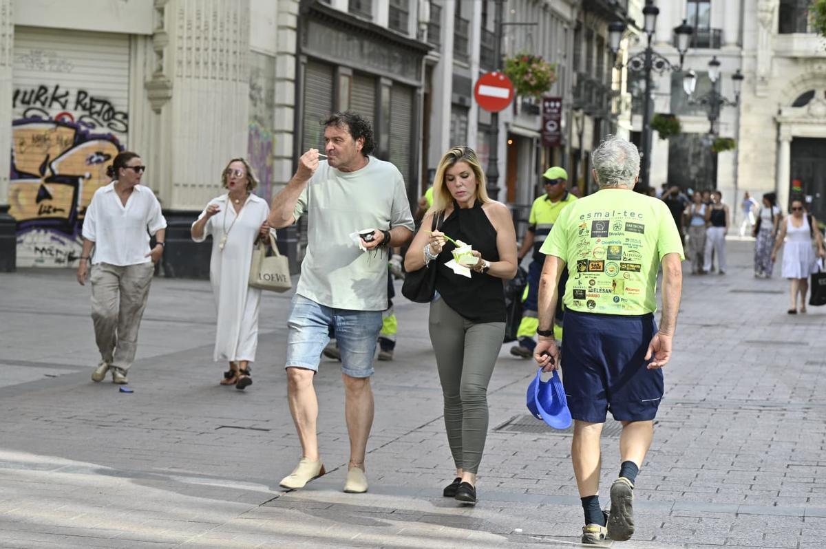 Dos personas se comen un helado en el centro de Zaragoza, este lunes durante la ola de calor.