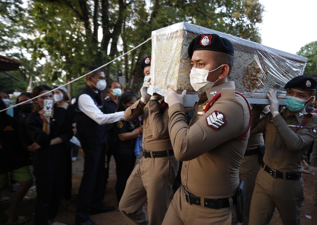 La gente observa cómo las piras funerarias incineran a 19 víctimas del tiroteo en la guardería de Uthai Suwan en el templo Wat Rat Samakee en Uthai Sawan. Un exoficial de policía disparó y mató a 37 personas, al menos 24 de ellos niños, después de irrumpir en una guardería infantil en el noreste de Tailandia.