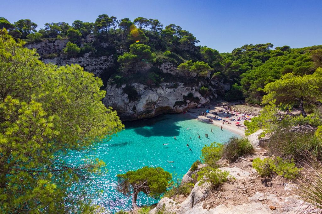 Turistas disfrutan del ambiente de la cala