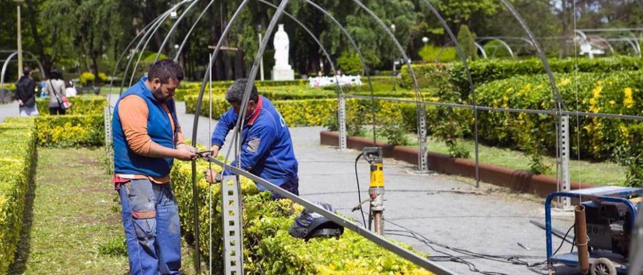 Dos operarios efectúan labores de renovación en el parque de Isabel la Católica.