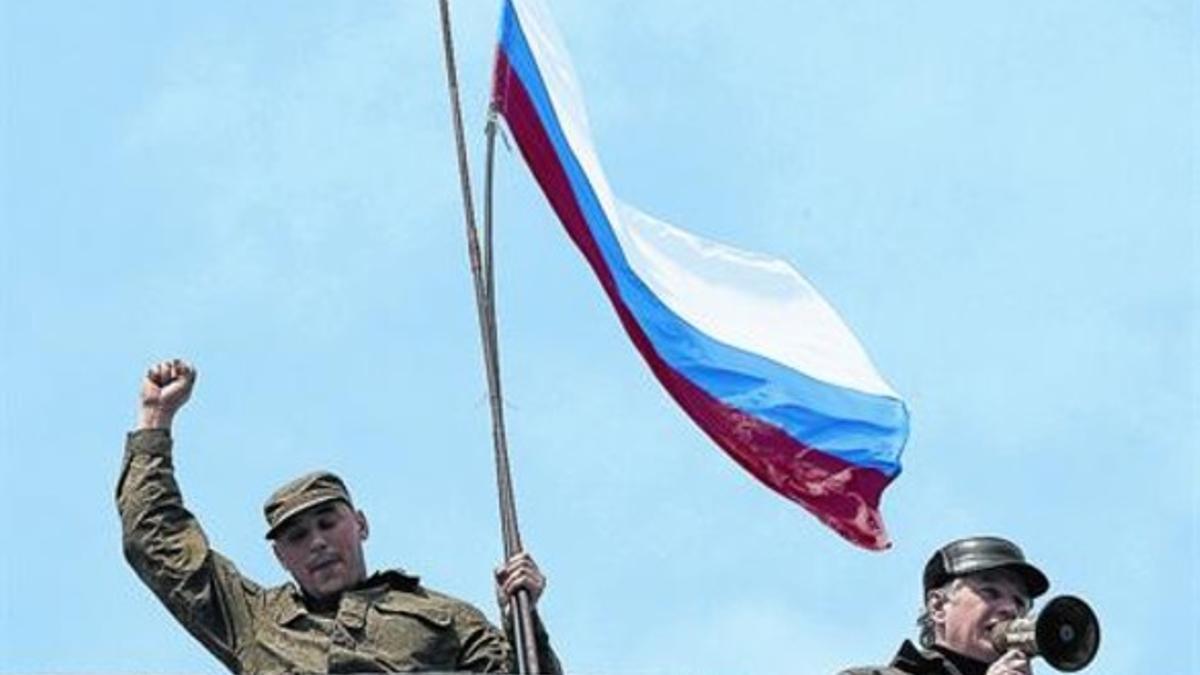 Un soldado sostiene una bandera rusa en la base naval de Sebastopol, ayer.