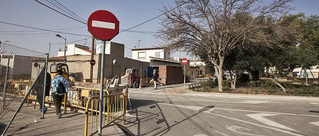 Dos vecinos pasean frente al parque del barrio.