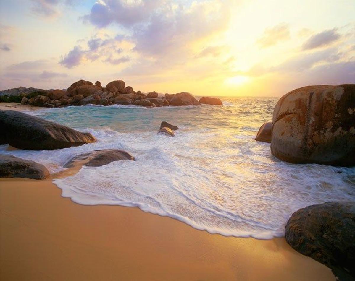 Atardecer en la playa de The Baths salpicada con enorme rocas graníticas.