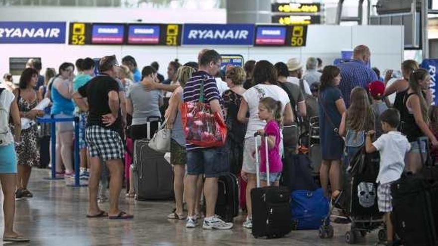 Pasajeros esperando cola para facturar en una compañía de bajo coste en el aeropuerto.