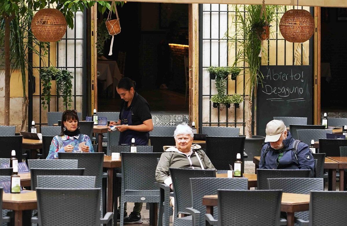 Una camarera atiende a los clientes en un establacimiento de hostelería en Málaga.