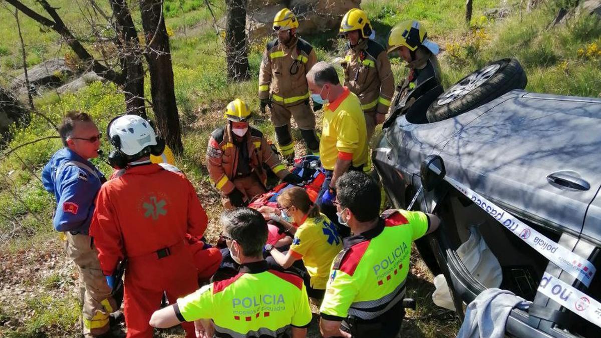 Els Bombers de la Generalitat, els Mossos d'Esquadra i el Sistema d'Emergències Mèdiques (SEM), durant el rescat d'un vehicle que ha caigut per un marge a Gironella