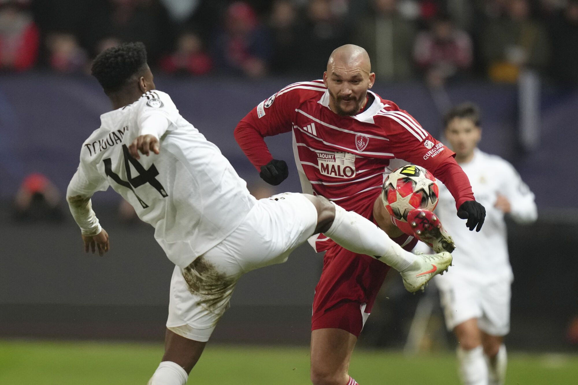 Brest's Ludovic Ajorque, right, challenges for the ball with Real Madrid's Aurelien Tchouameni during the Champions League opening phase soccer match between Brest and Real Madrid at Roudourou stadium in Guingamp, France, Wednesday, Jan. 29, 2025. (AP Photo/Thibault Camus). EDITORIAL USE ONLY / ONLY ITALY AND SPAIN
