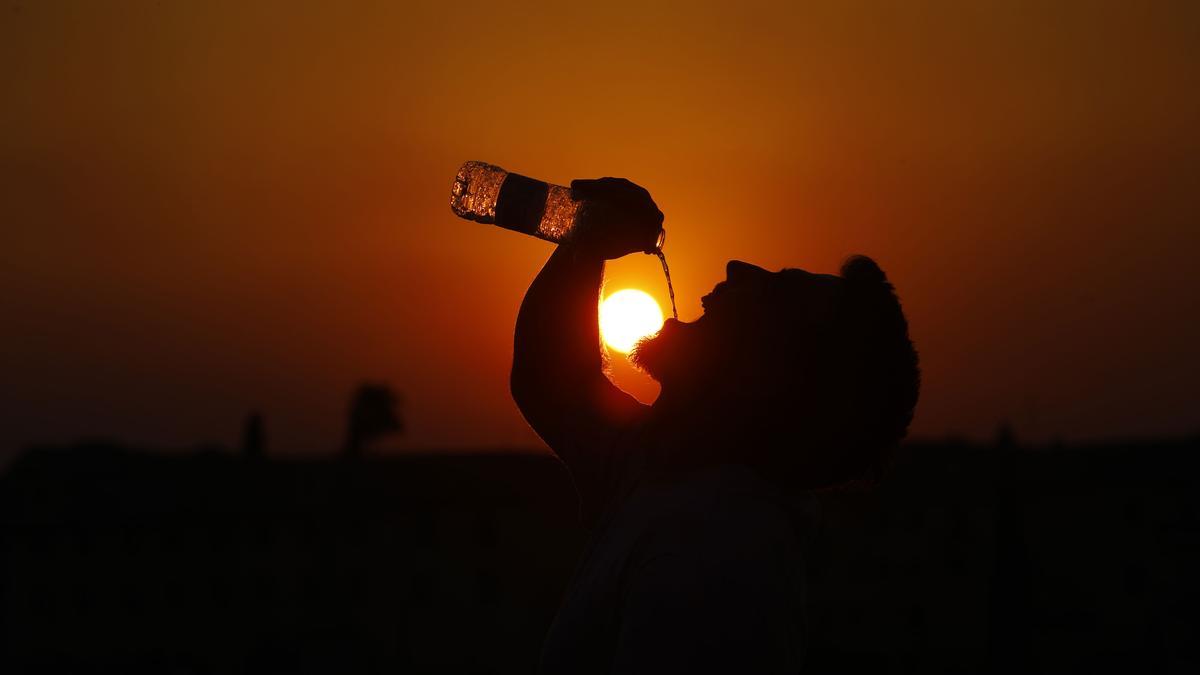 Un hombre bebe agua para mitigar los efectos de la ola de calor.