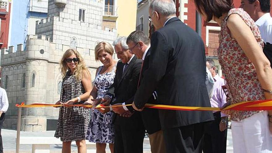 A la izquierda, corte de cinta de la inauguración. A la derecha, una vecina pasea próxima al borde del paseo con la playa.